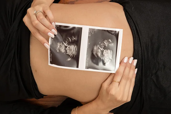 MC Productions NJ – Maternity portrait featuring hands on belly in artistic lighting