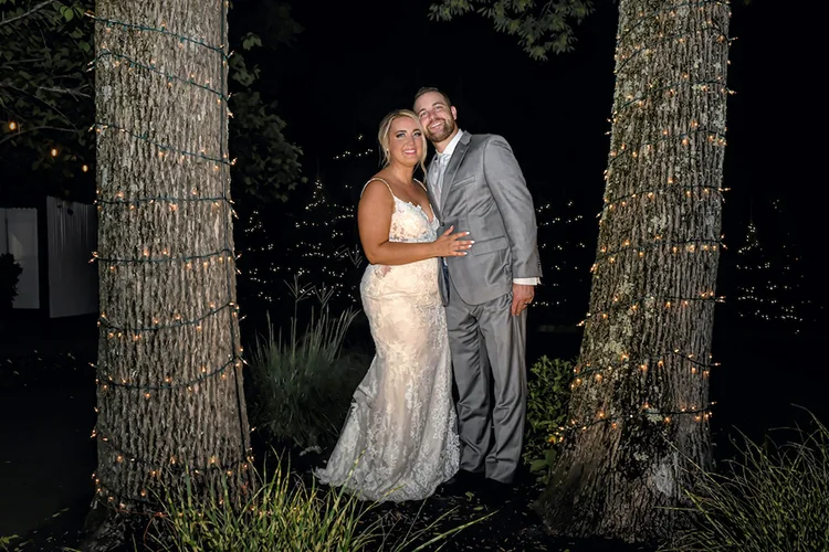 ighttime bride and groom portrait among string-lit trees at Forest Lodge in Warren, NJ