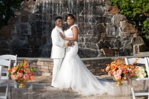 Couple embracing by the stone fountain at their Royal Manor wedding
