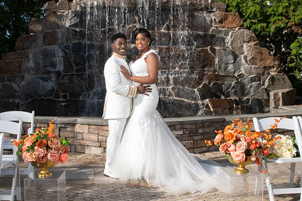 Couple embracing by the stone fountain at their Royal Manor wedding