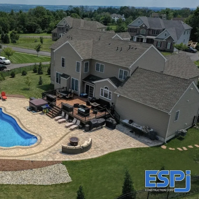 Aerial drone photo of a luxury home backyard with a new pool and paver patio built by ESPJ Construction