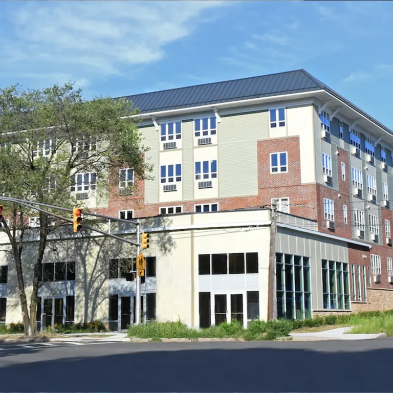 Architectural photo of a newly built four-story mixed-use building at a New Jersey intersection